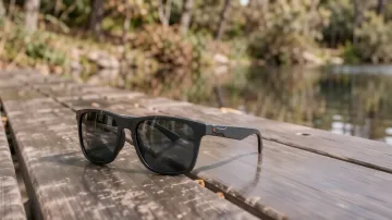 Polarisierte Sonnenbrille auf spiegelnder nasser Fläche