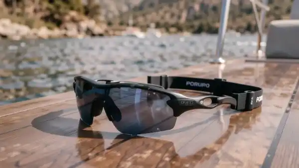 Wassersportbrille mit Halteband auf nassem Bootsdeck